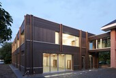 West facade with the seven meter wide window front and the passerelle into the old building